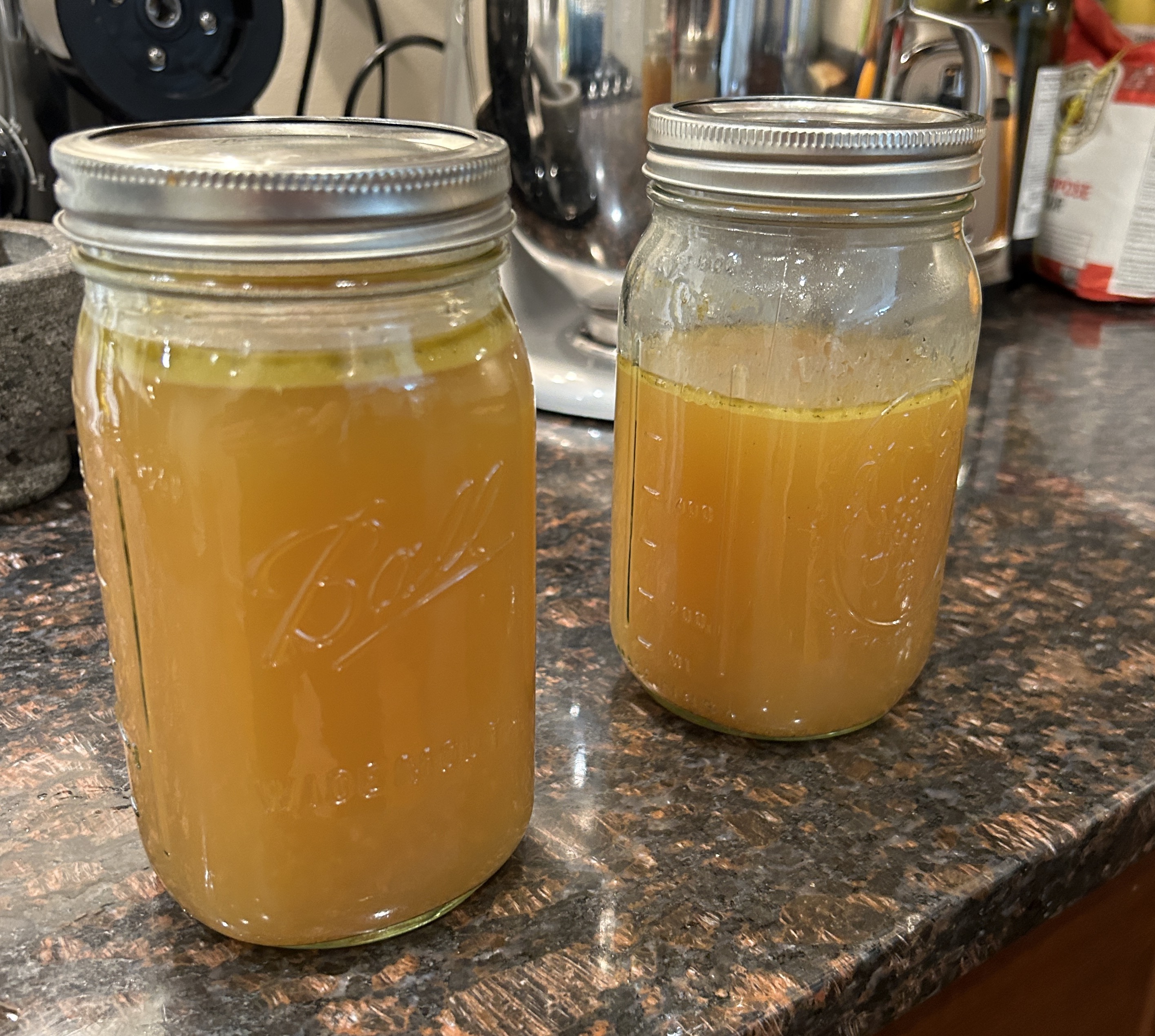 Two mason jars of chicken stock